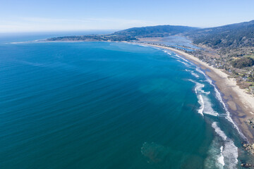 Naklejka na ściany i meble North of San Francisco, the Pacific Ocean washes against the shoreline of Stinson Beach on a beautiful winter day. The scenic Pacific Coast Highway runs along much of the edge of California.