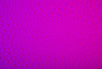Closeup of water droplets creating a pink color background