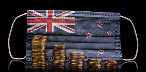 Medical mask with the flag of New Zealand behind some shrinking stacks of various coins.(series)