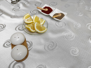 lemon black pepper, red pepper and spoon-forks at the dinner table,
