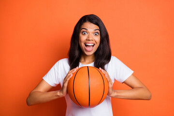 Photo of excited funny lady hold ball open mouth wear white t-shirt isolated orange color background