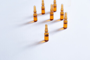 Brown ampoule with medicine on a gray background.Skincare products.Ampoules with vitamin C.Beauty industry.Coronavirus vaccination.