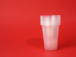 white transparent disposable cups on red background