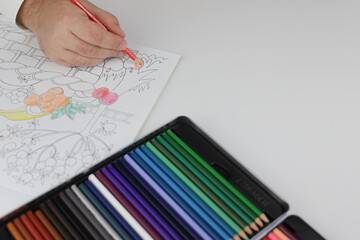 Drawing mandala anti stress with multicoloured pencils during lockdown.