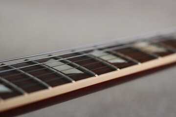 Close up of guitar neck showing fretboard and strings