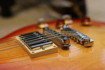 Electric guitar bridge pickup and stoptail bridge close up © Grant