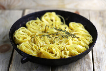 Selective focus. Nest fettuccine pasta in a frying pan. Making fettuccine pasta.