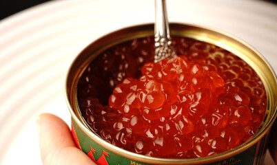 Red caviar in a jar just opened. We take it with a spoon.