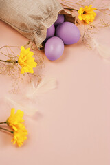 Easter eggs and spring flowers on a colorful background. Happy Easter. Holiday concept. Copy space.