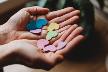 hands holding little valentine's colorfull hearts 