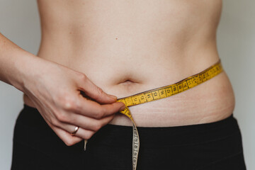 woman measuring her waist