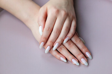 Model woman showing .light white nude shellac manicure on long nails