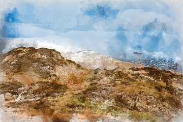 Majestic Winter landscape image view from Holme Fell in Lake District towards snow capped mountain ranges in distance in glorious evening light with Autumnal colors trees