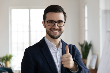 Photo portrait of loyal customer evaluating good quality with like gesture. Satisfied customer recommends business coach training. Person raising thumb up, looking at camera. Positive feedback concept