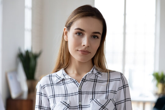 Profile picture of serious beautiful woman in casual wear looking at camera. Head shot of young millennial female student or company intern posing in modern office. Job candidate portrait concept