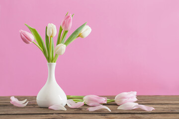 Obraz na płótnie Canvas tulips in white vase on pink background