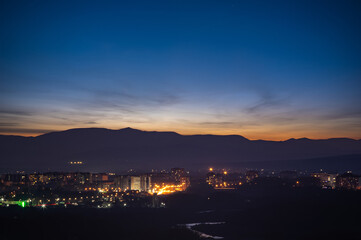 City in the background of mountains and river at sunrise