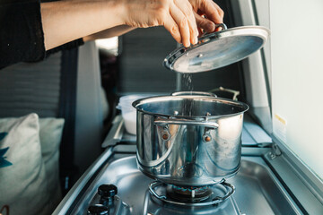 A young woman having breakfast in her caravan observing a good view of the beach
