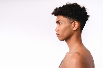 Side view portrait of a young handsome mixed-race man without clothes isolated over white background