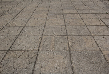 The sidewalk is paved with square decorative tiles.