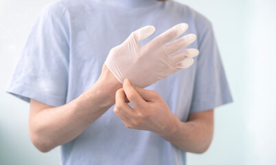 close up person try to put on protective gloves on hands to protect from the coronavidus epidemic