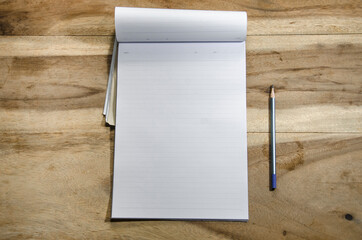 paper and pencil on wooden background