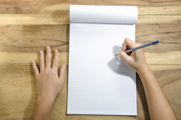 hand writing a paper  on wooden background