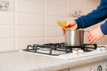 hands holding a bunch of raw spaghetti and cook it. italian noodle pasta traditional