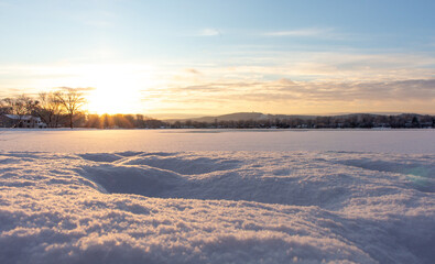 beautiful glowing winter sunset over snow covered lake