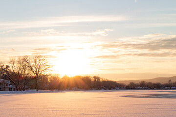 Fototapeta na wymiar beautiful glowing winter sunset over snow covered lake