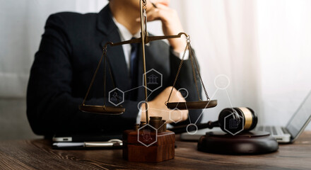 Justice and law concept.Male judge in a courtroom with the gavel, working with, computer and docking keyboard, eyeglasses, on table in morning light