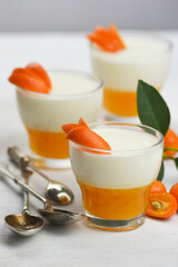 Italian dessert panna cotta with mandarin jelly  decorated with slice of fruits on white background.