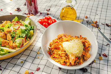 A summer picnic atmosphere, tablecloth on the lawn with plates of healthy food and fruit drinks. Flat lay food. Olive oil, salads, sandwich, quinoa salad, vegan burger