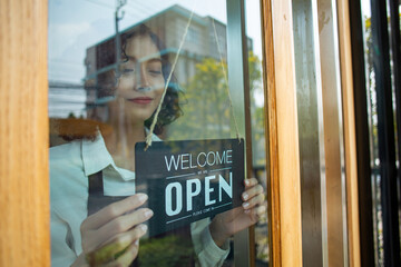 Store owner woman turning open sign wood broad to ready service food and beverage