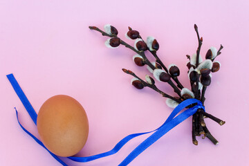 Happy Easter. A bouquet of pussy willow branches and an egg on a light background. Easter composition. Blank for an Easter card. Copy space.