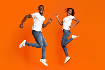 Fototapeta na wymiar Lifeful african american couple running in the air, studio shot