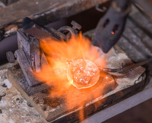 Melting process of precious metal gold behind a jeweler's workbench