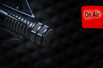 Professional microphone in radio station studio and on air sign