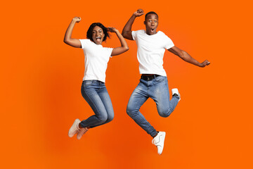 Fototapeta na wymiar Happy black man and woman celebrating success, full length photo