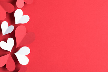 White and red hearts on a red background. The concept of St. Vylentin Day. Festive background. Copy space.