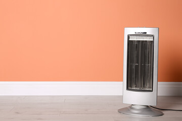New modern electric heater on floor in room, space for text