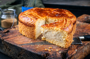 Traditional French gateau basque cake with vanilla cream and pate sablee served as close-up on a rustic wooden board