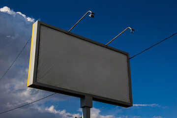 Billboard on the background of a blue summer sky.