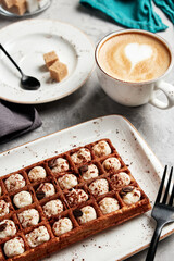 large waffles with filling on a gray background with coffee