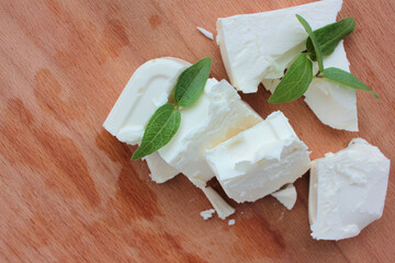 Sliced feta cheese on cutting board background. Overhead view, close-up