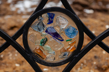 A decorative element of a street bench in the form of a circle made of multicolored glass - Powered by Adobe
