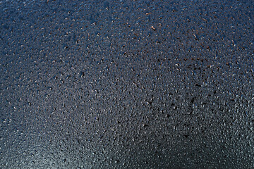 Dark metal background with water drops. Blank surface for the backdrop. 
