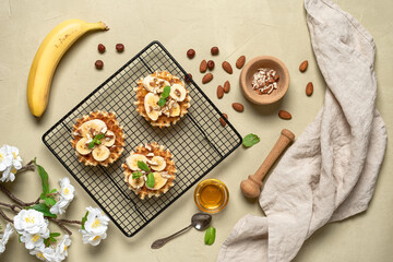 Homemade Belgian waffles with banana, nuts and honey on a beige concrete background. Top view, flat lay.