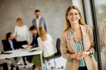 Young business woman standing in the office in front of her team