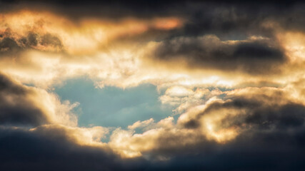 Dramatic sky with storm clouds. Beautiful sunlight shining through the clouds. Sky background.